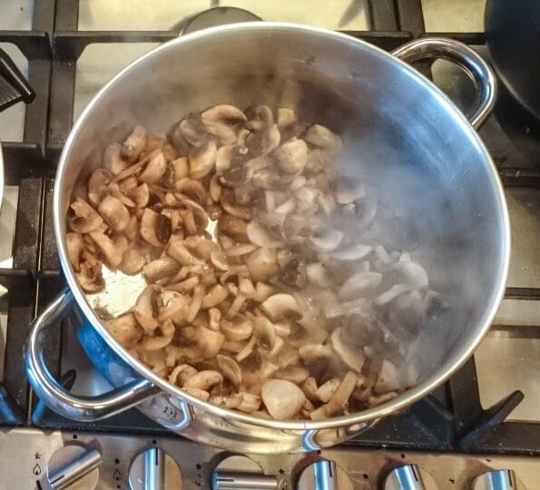 Champignons aanstoven met ui en look.